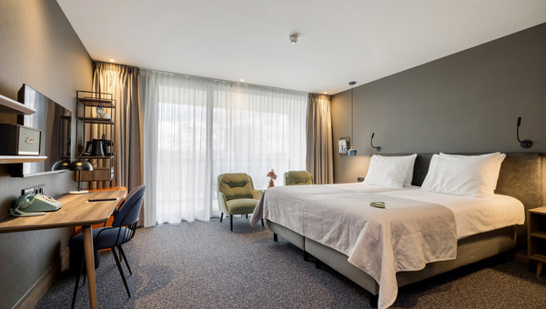 Modern ingerichte Superior Twin Room met een comfortabel tweepersoonsbed, grote ramen en een zithoek